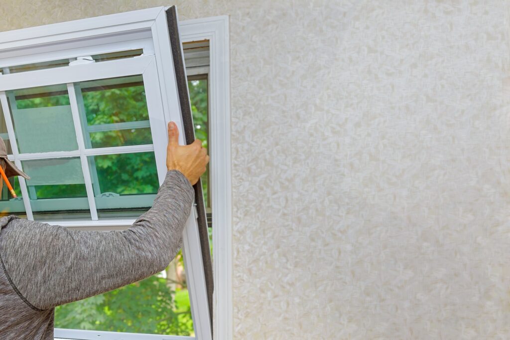 Worker in the installing new, windows in an house, with a new window in the home renovation living